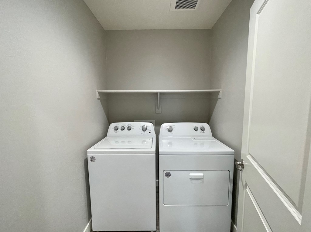 an empty laundry room with two washes and a dryer