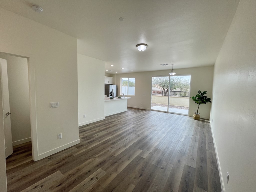 an empty living room with hardwood flooring and a window