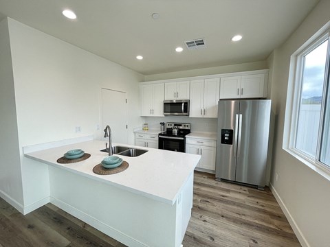 a kitchen with a large island and a stainless steel refrigerator