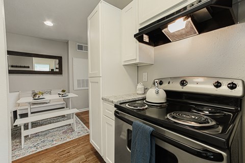 A white stove with a kettle on it in a kitchen.