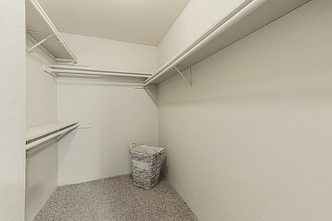 A small room with a carpeted floor and a trash can.