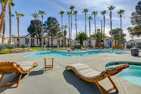 a pool with lounge chairs and palm trees in the background