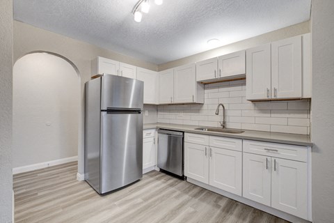 a kitchen with white cabinets and stainless steel appliances