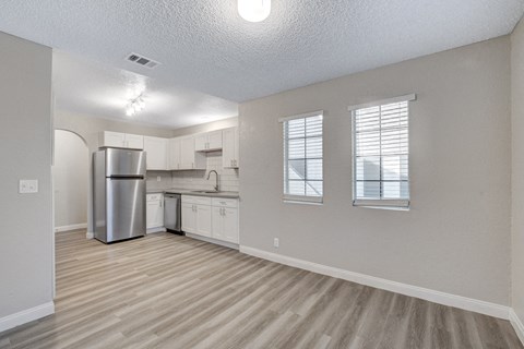a kitchen with white cabinets and a stainless steel refrigerator