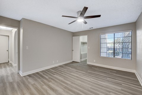 an empty living room with a ceiling fan