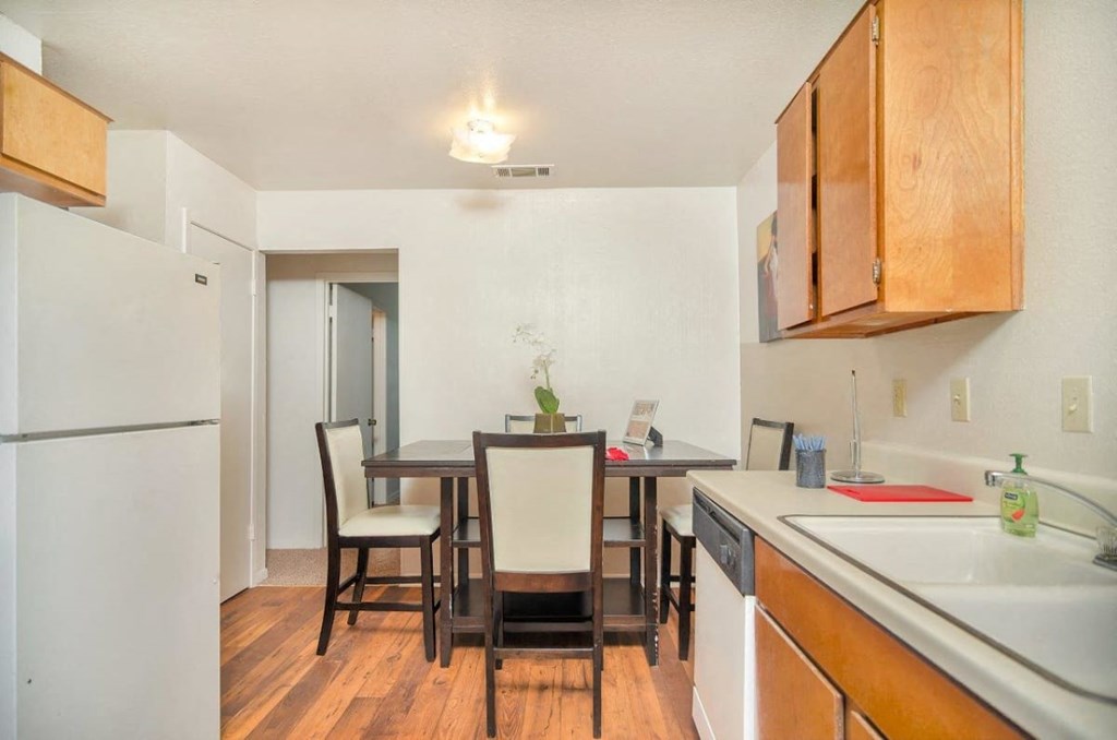 A kitchen with a table and chairs.