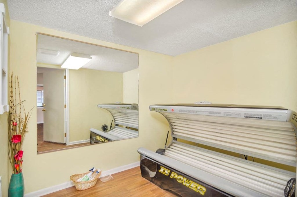A tanning bed is in a room with a mirror.