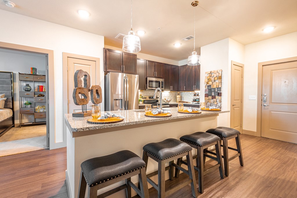 a kitchen with a counter top with three stools