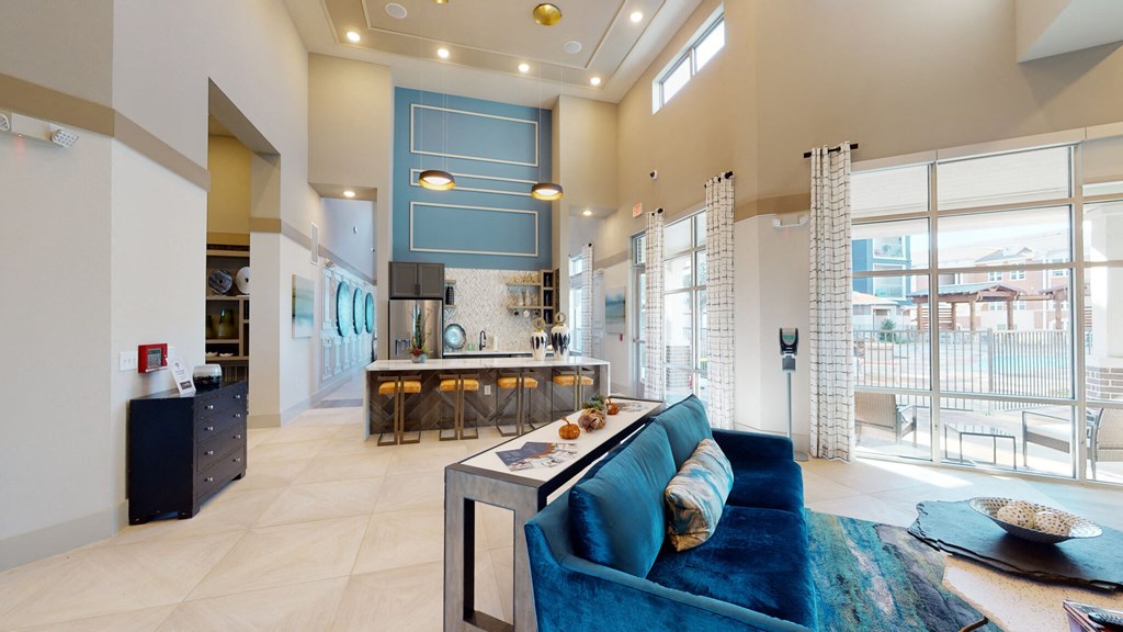 a living room with a blue couch and a kitchen with glass doors