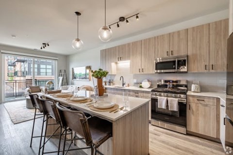 A modern kitchen with wooden cabinets and a large island.