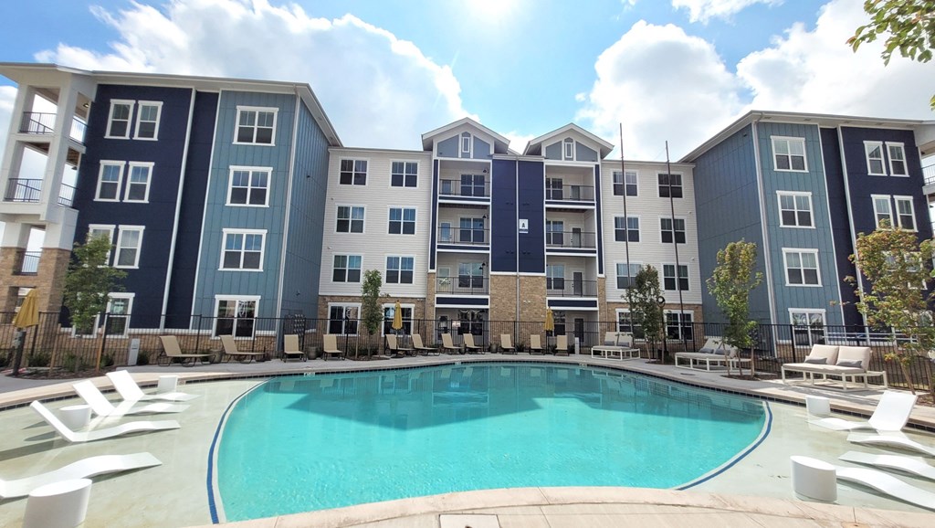a swimming pool with an apartment building in the background