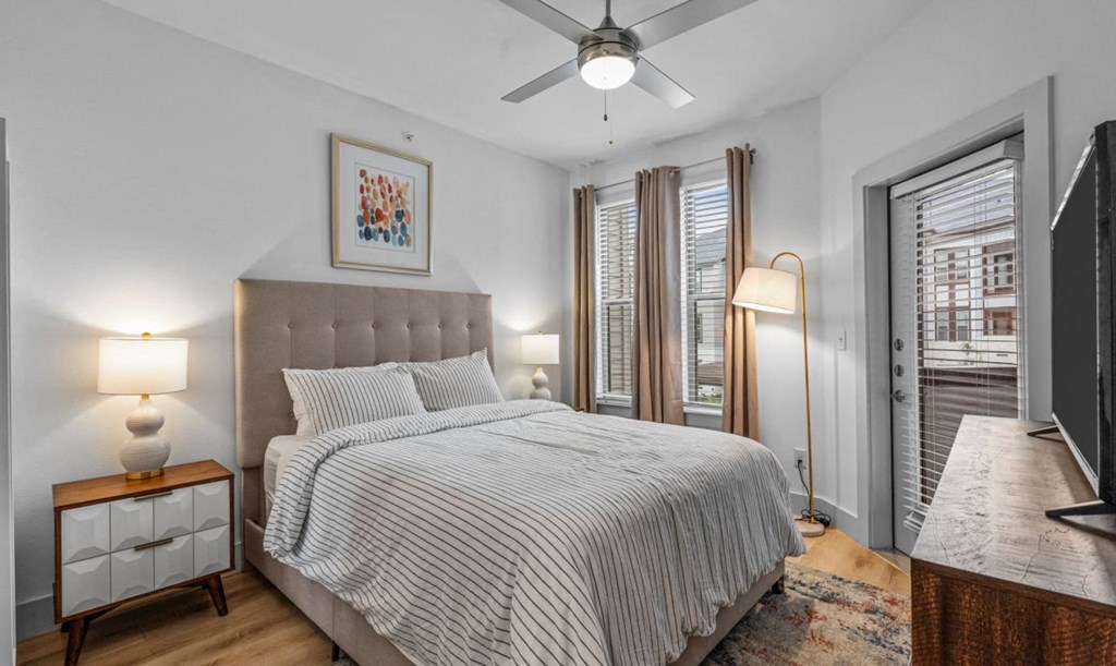 a bedroom with a bed and a ceiling fan