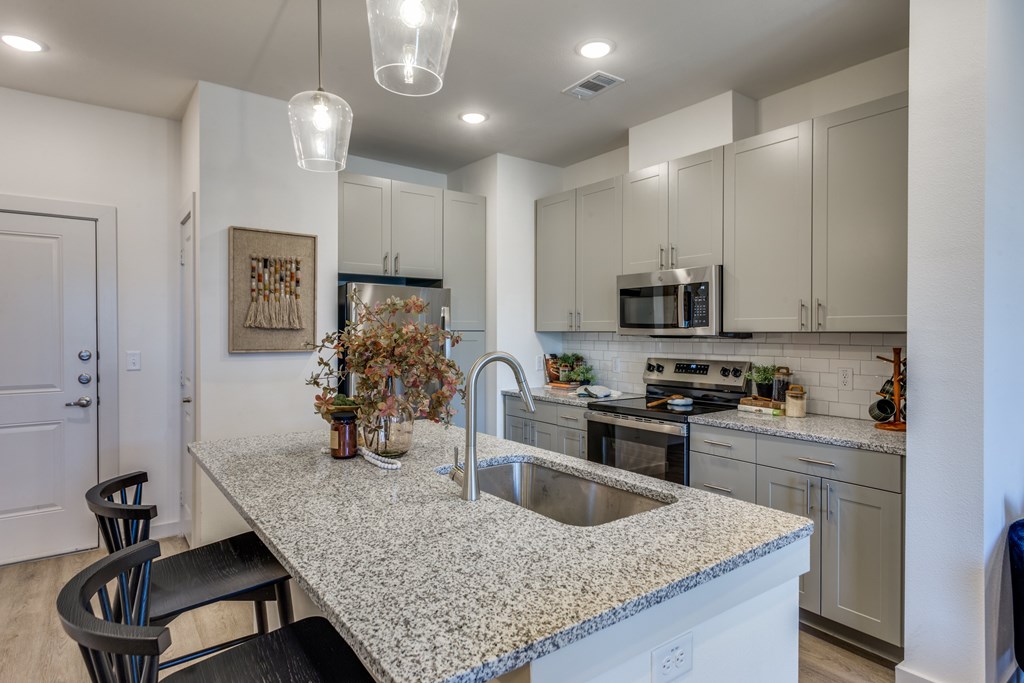A kitchen with a granite countertop and a sink.