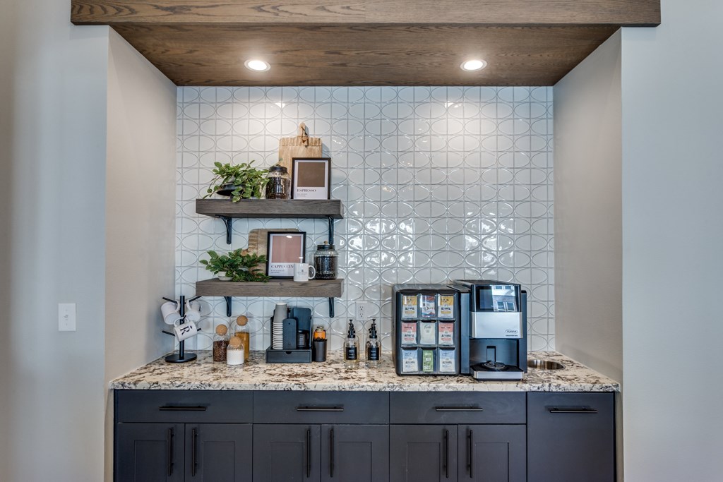 A kitchen with a marble countertop and a wooden shelf above it.