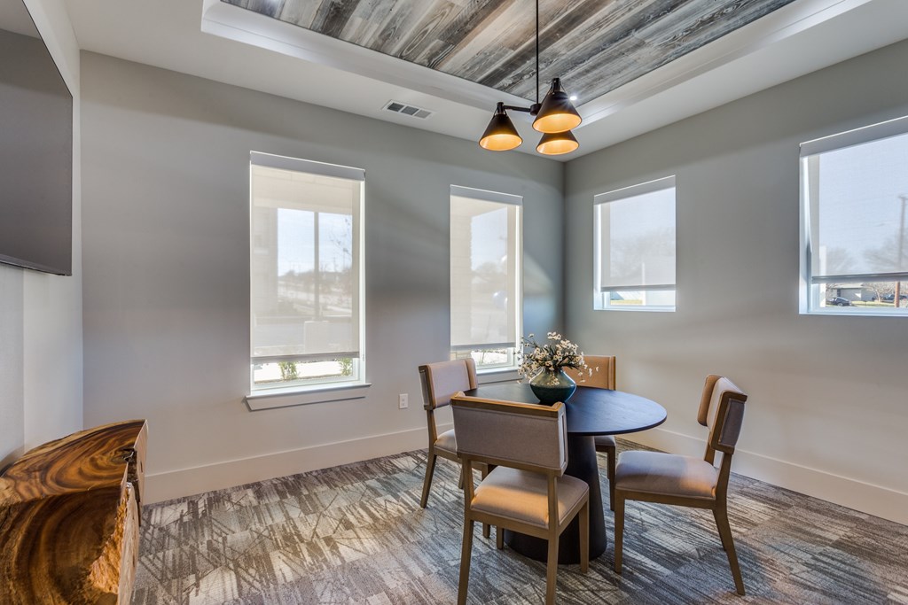 A dining room with a round table and chairs.