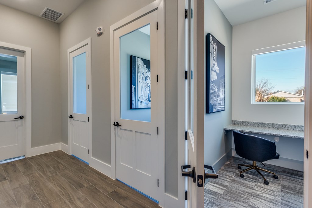 A room with a desk and a chair in it.