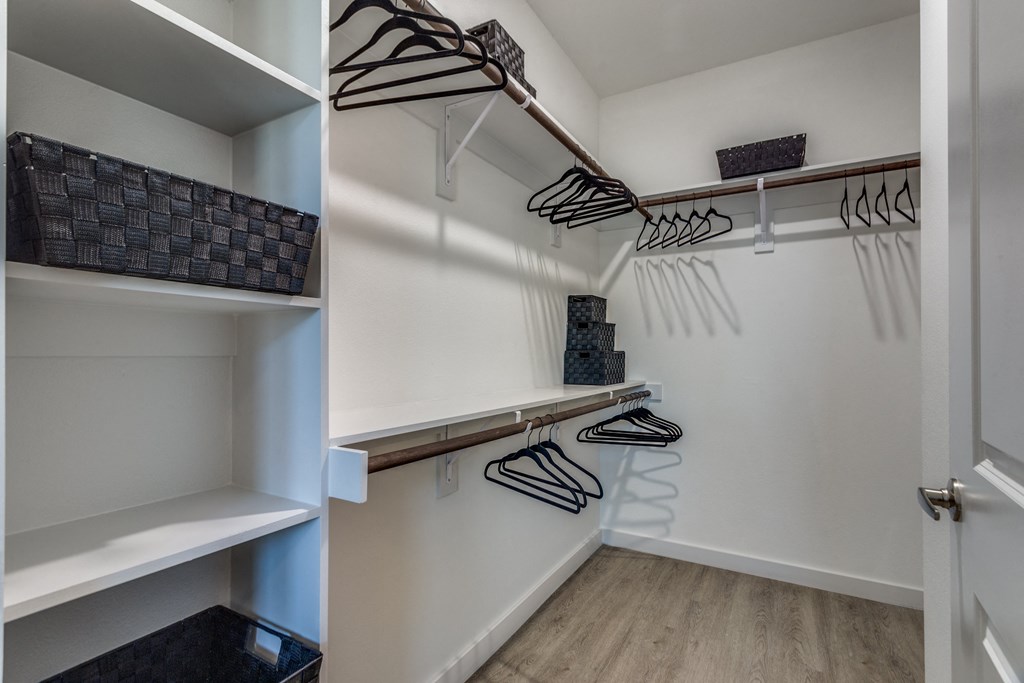 A white closet with a white door and a white shelf.