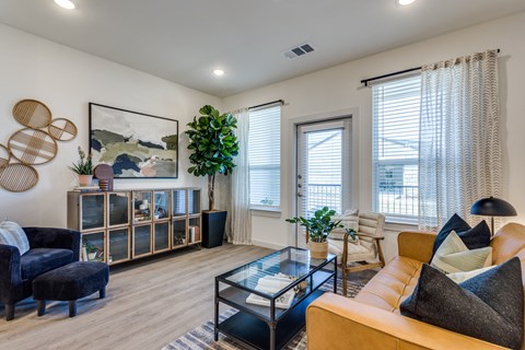 A living room with a glass coffee table and a yellow couch.