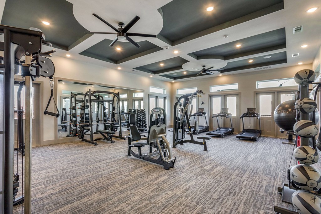 A spacious gym with a variety of equipment including treadmills, weights, and exercise machines.