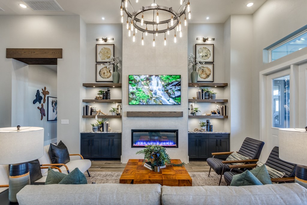 A living room with a large flat screen TV mounted on the wall above a fireplace.