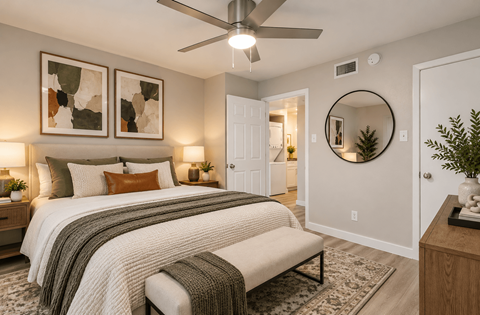 A bedroom with a large bed and a ceiling fan.