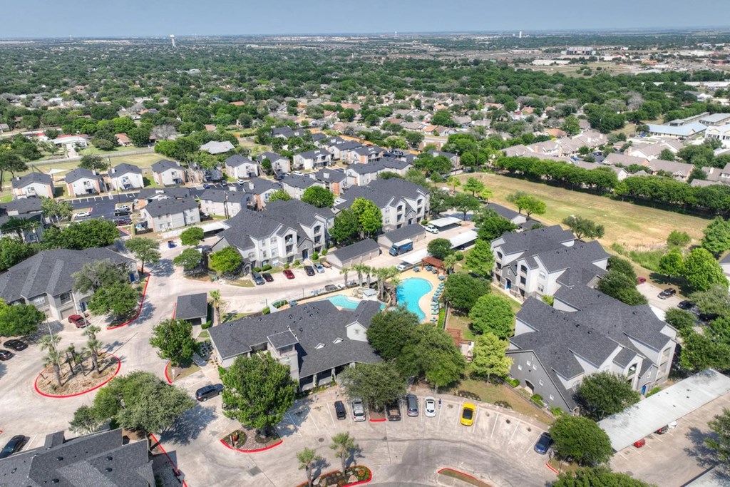 A bird's eye view of a residential area with houses and a swimming pool.