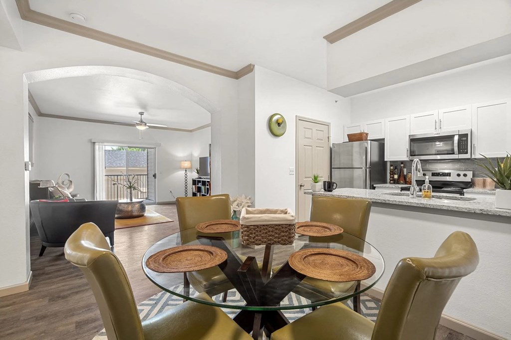 A modern dining room with a glass table and chairs.