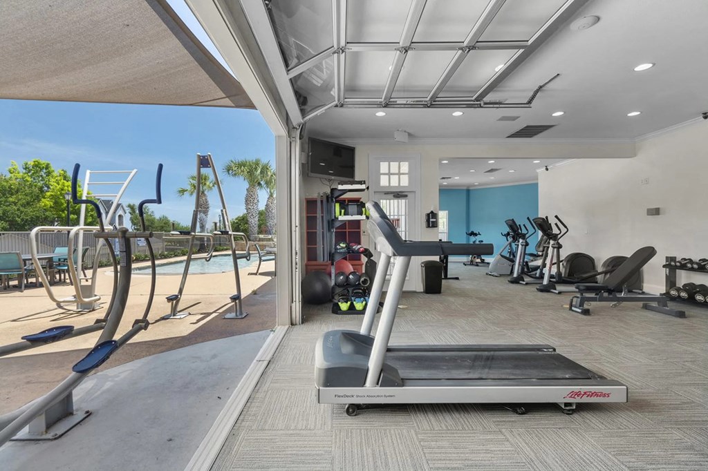 A treadmill is in the middle of a room with exercise equipment.