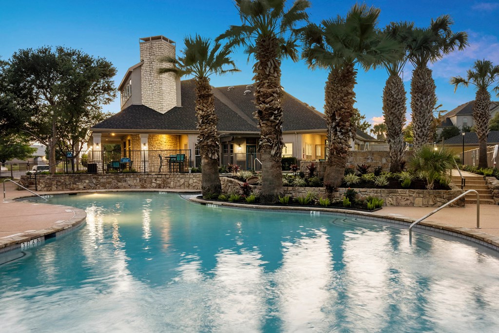 A house with a pool surrounded by palm trees.
