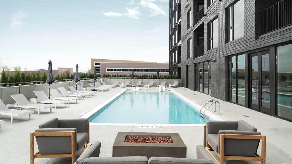 a swimming pool in the middle of a building with lounge chairs