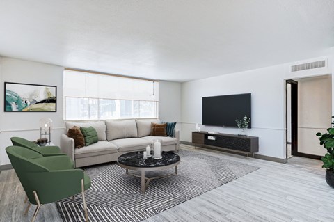 the living room of an apartment with a couch and a tv