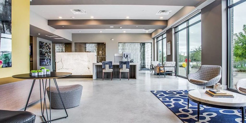 A modern living room with a dining area and a kitchen in the background.
