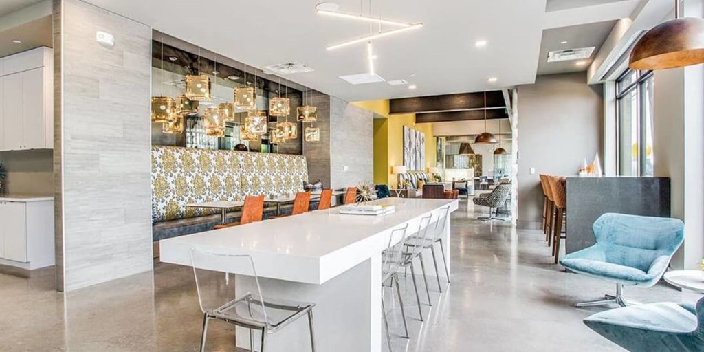 A modern kitchen with a long white island and bar stools.