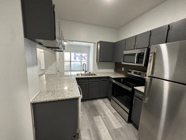 an empty kitchen with stainless steel appliances and granite counter tops