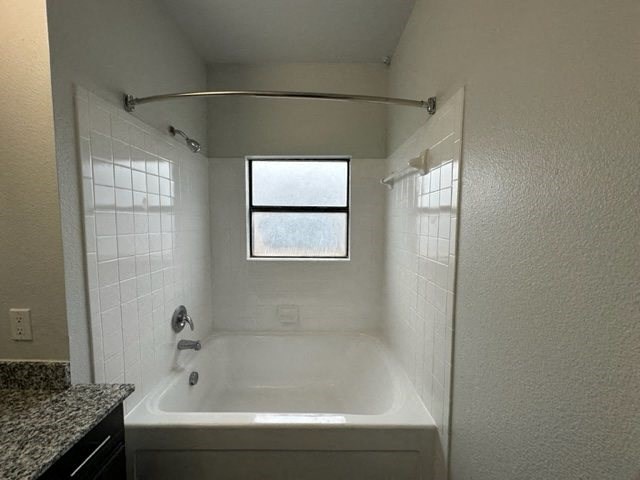 a white bathroom with a tub and a window