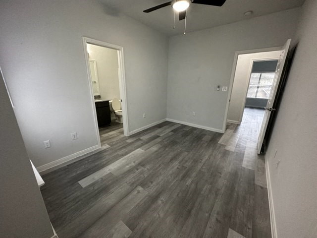a empty living room with wooden floors and a ceiling fan