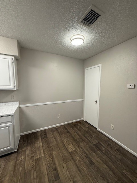 A room with a white door and a white cabinet with a counter top.