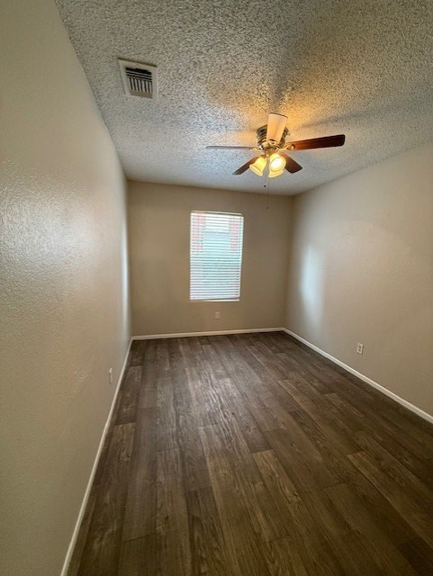 A room with a ceiling fan and wooden flooring.