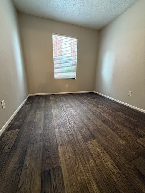A room with wooden flooring and a window with blinds.