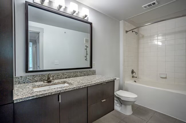 A bathroom with a sink, toilet, and bathtub.
