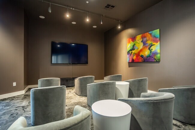 A room with grey chairs and a painting on the wall.