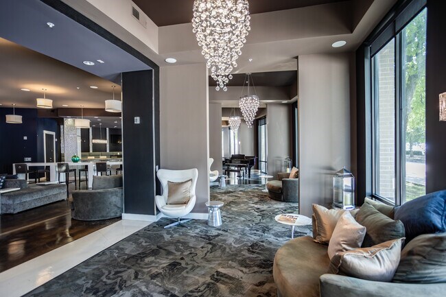 A modern living room with a large chandelier and a sofa.
