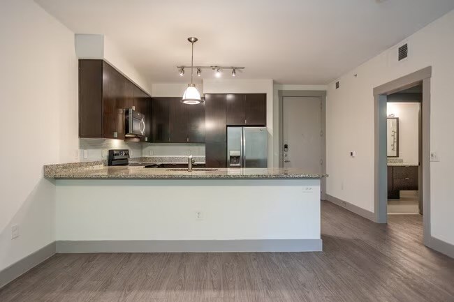 A kitchen with a granite countertop and a white island.