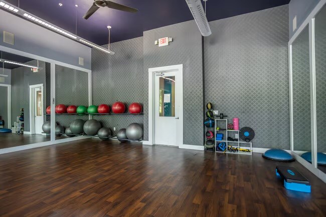 A gym with a variety of equipment including exercise balls and resistance bands.