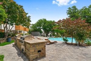 a backyard with a grill and a swimming pool