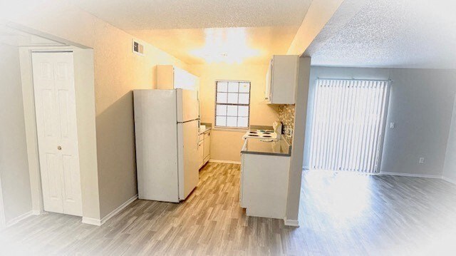 an empty kitchen with a refrigerator and a sink