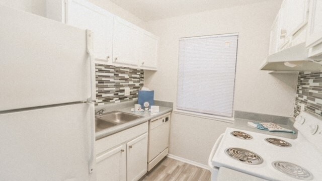 a white kitchen with a stove and a refrigerator
