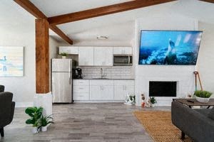 a kitchen and living room with a large tv