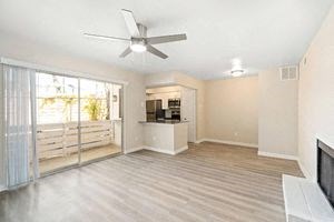 a living room with a ceiling fan and a sliding glass door