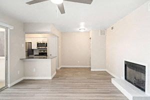 a living room with a fireplace and a kitchen